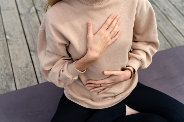 Woman's hands on her chest while doing breathing exercises