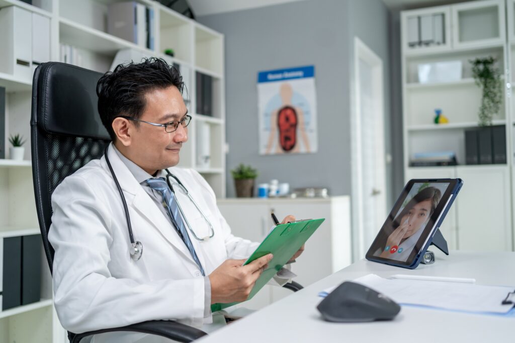 Asian doctor providing telehealth video consultation to online patient.